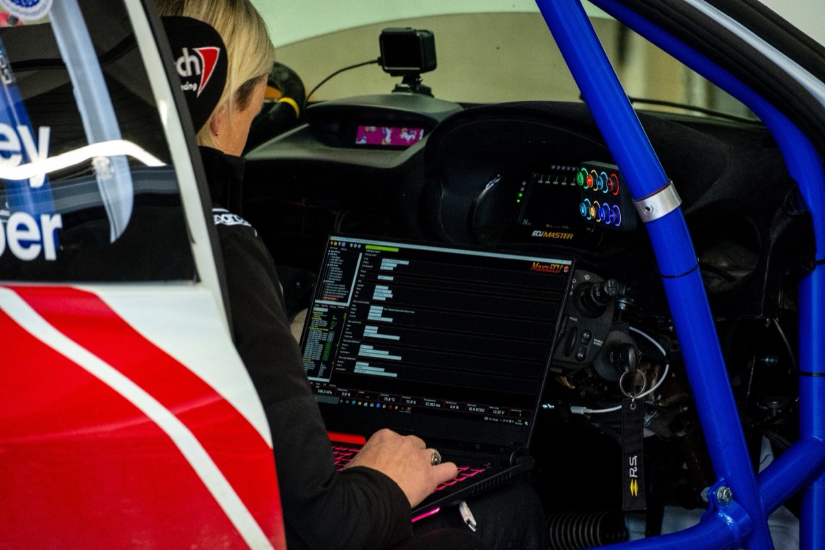 Diagnostic laptop connected to a vehicle's ECU during a tuning session