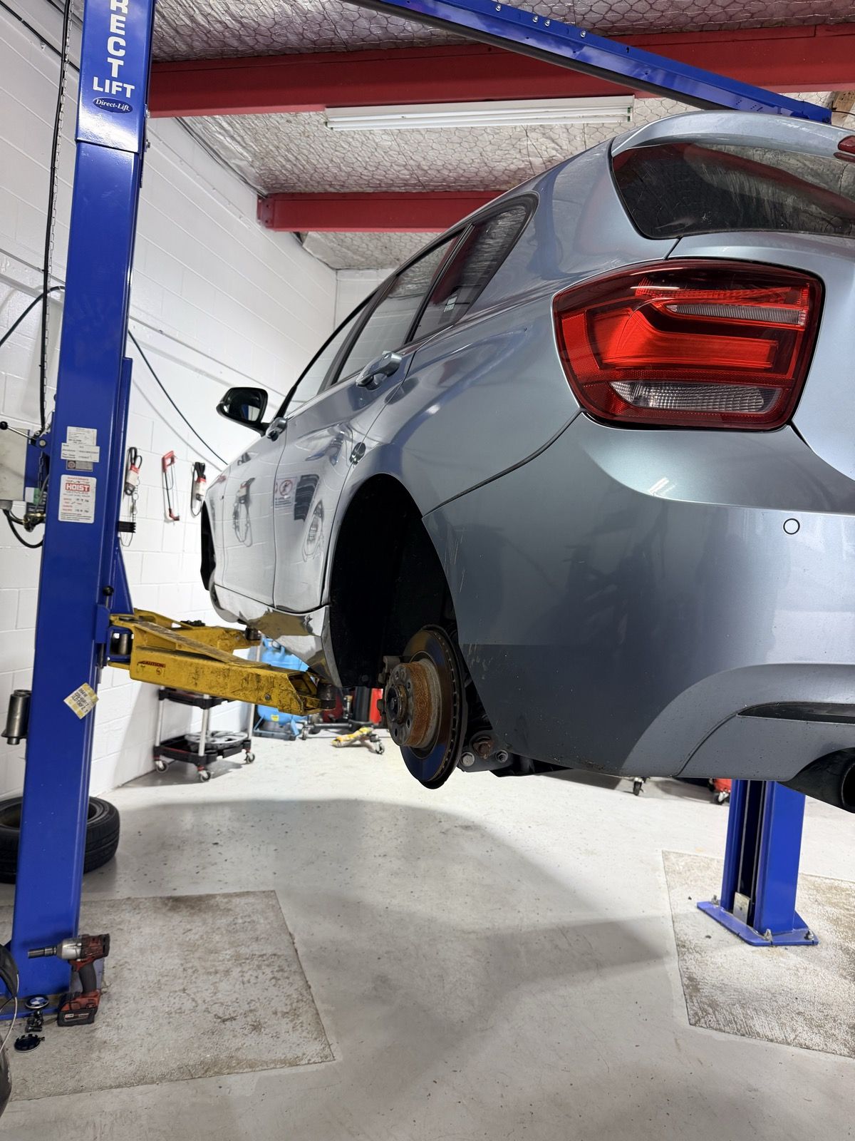 BMW up on a hoist for brake work in our Wiri workshop