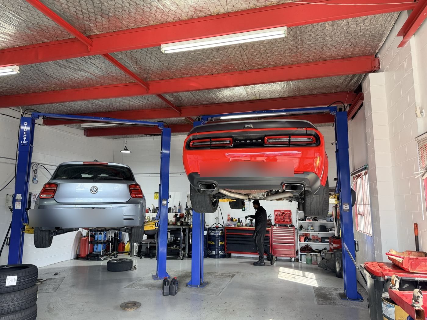 BMW and performance vehicle up on hoists in our Wiri workshop