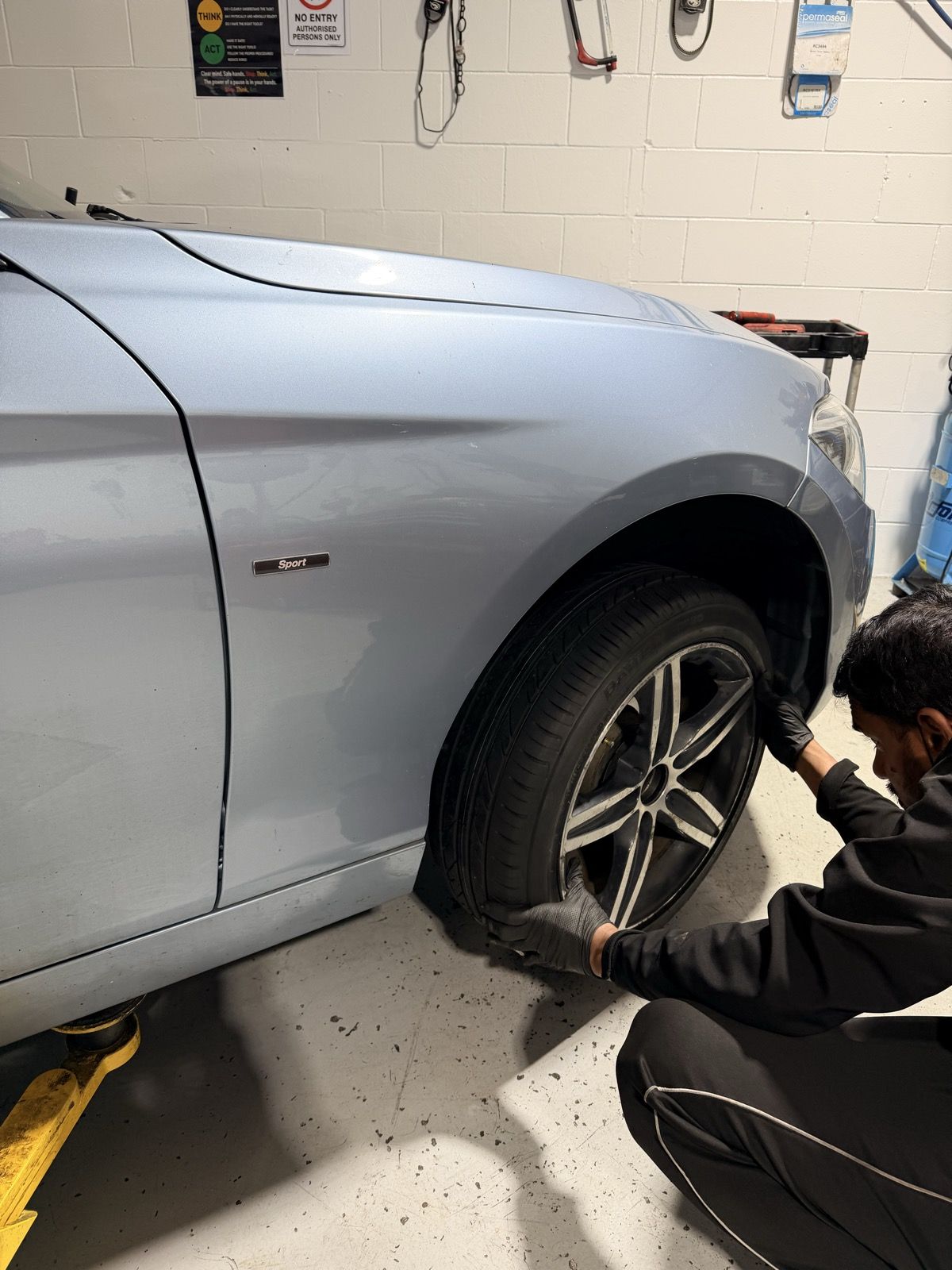 Mechanic fitting a wheel back on during a service